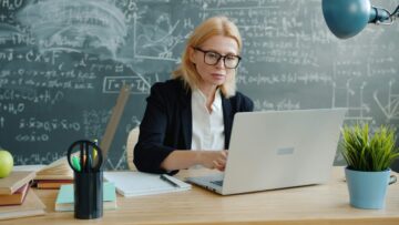 Estudiante escribiendo un ensayo en su ordenador portátil con esquemas y apuntes para preparar la prueba de Writing de inglés