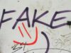 Graffiti en una pared blanca con la palabra FAKE (falso) pintada en letras moradas, simbolizando la trampa visual y el engaño de los falsos amigos en el vocabulario en inglés