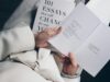 Primer plano de una persona leyendo un libro de ensayos, representando la redacción y estructura de textos académicos en inglés