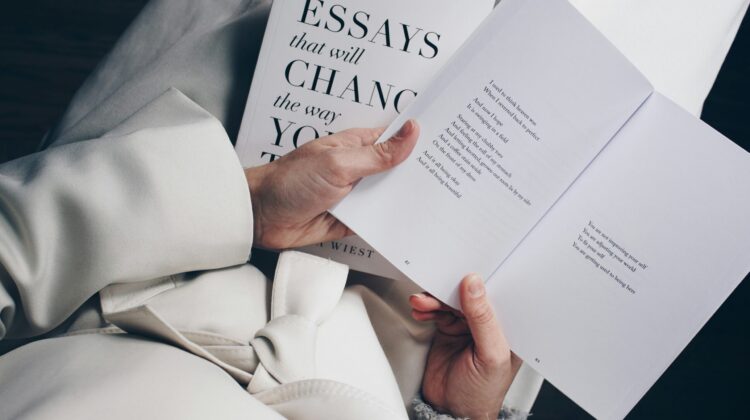 Primer plano de una persona leyendo un libro de ensayos, representando la redacción y estructura de textos académicos en inglés