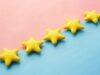Cinco estrellas amarillas alineadas sobre un fondo rosa y azul, representando la valoración y el veredicto final de una reseña (review) en inglés
